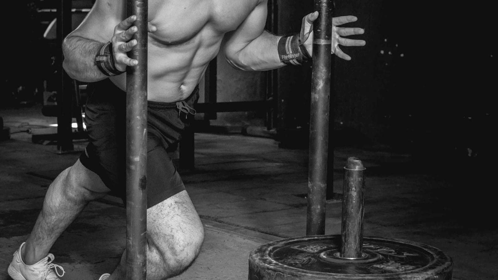 Atleta che spinge una slitta zavorrata